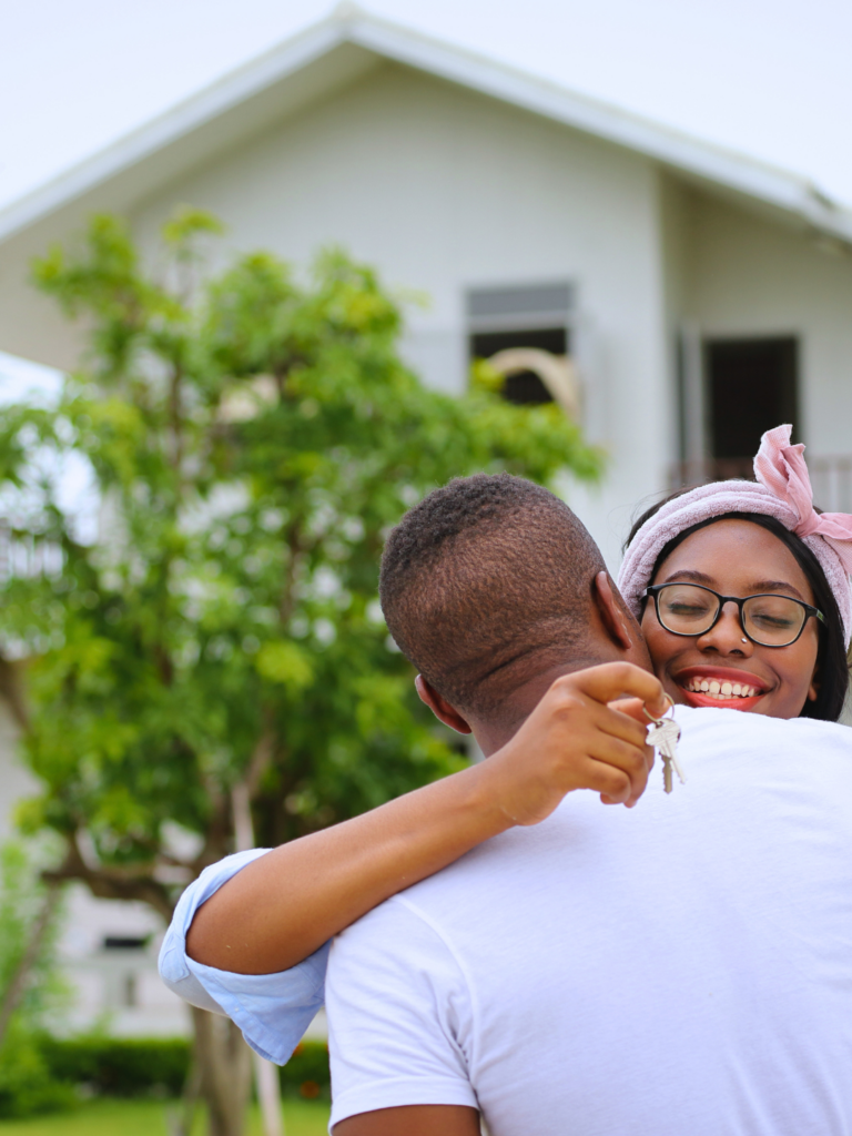 Image of young couple infront of their first home by the coast. Coastal Finance - finance brokers based in Tasmania and Victoria - Australia.